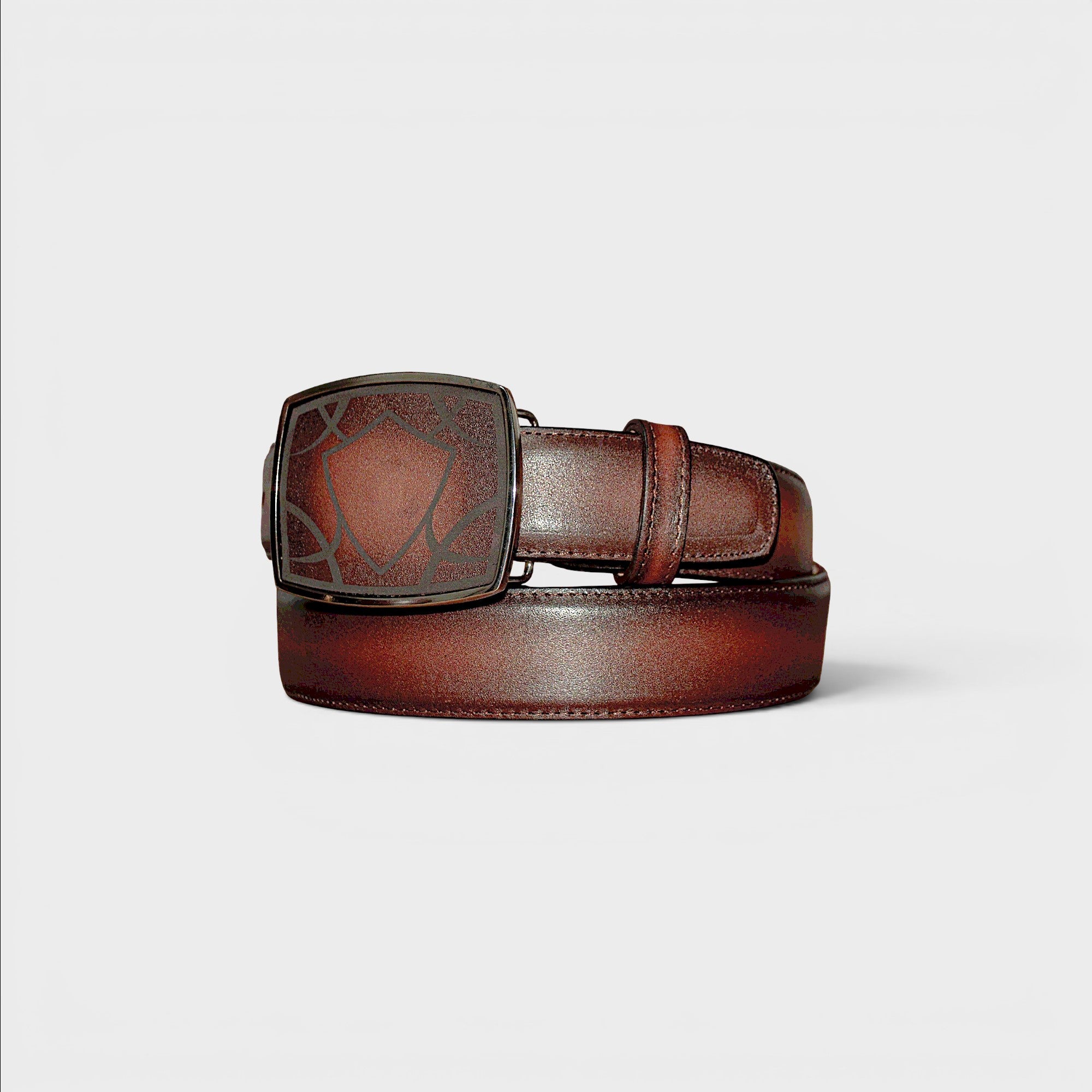 Cinturón VIARCI BELTS de piel marrón degradada con hebilla metálica grabada en forma de escudo.